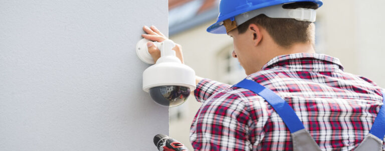 A Man Installing A Low Voltage Security Camera